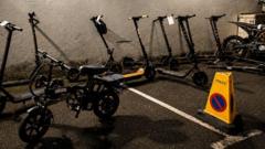 A yellow cone has the word police displayed on it. Electrical bikes are parked next to it. It's night.