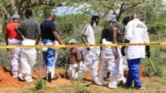Detetives quenianos e especialistas forenses examinam um túmulo na floresta Shakahola em Kilifi, no Quênia