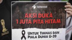 Anggota komunitas CentennialZ memegang poster saat melakukan "Aksi Duka 1 Juta Pita Hitam" di kawasan Senayan, Jakarta, Jumat (31/03)