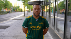 Jack Hudson, 21, electrician from Nottingham, stands in a busy street with his arms behind his back, wearing a cricket T-shirt