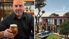 Barman raises a glass after £3.5m Omaze house win