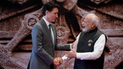 Trudeau (à esq.) e Modi apertando as mãos; Trudeau tem feição séria, enquanto Modi sorri