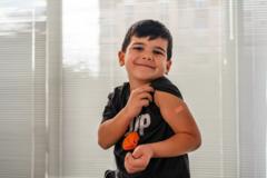 menino com curativo pós-vacina no braço