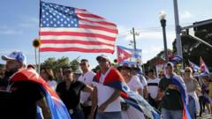 Dezenas de pessoas na rua com bandeiras dos EUA e de Cuba
