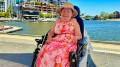 Melanie for her weelchair in front of swimming pool