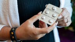 Mulher segura cartela de pílulas abortivas