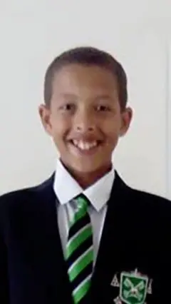 Noah Donohoe is a white shirt, green black and white tie and a black school blazer. 