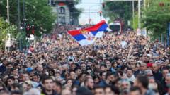 A protester waves a Serbian flag over a crowd in the capital, Belgrade