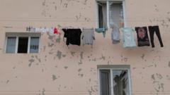 Laundry hanging on a building next to shattered windows in Stepanakert, after shelling