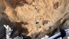 Moment person clinging to cliff is rescued by helicopter