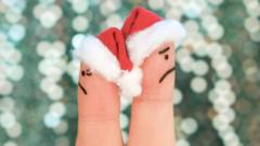 Dois dedos com gorro de papai noel simbolizando duas pessoas brigadas no Natal