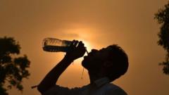 A man drinks water from a bottle in front of a hot Sun