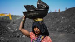 Workers carry coal at a coal yard near a mine on November 23, 2021 in Sonbhadra, Uttar Pradesh India. India is rapidly transitioning to renewables, investing in widespread solar and wind installations, though it still remains reliant on coal for about 70% of its energy needs, media reports said.