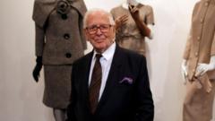 Pierre Cardin stands in front of dummies bearing his clothes, 2014