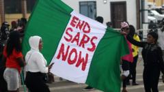 Protesters hold a Nigerian flag with an inscription during a protest against the Nigeria rogue police, otherwise know as Special Anti-Robbery Squad (SARS), in Ikeja district of Lagos, Nigeria, 15 October 2020