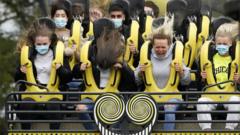 Members of the public wear face masks as they ride "The Smiler" rollercoaster at Alton Towers on July 4, 2020 in Alton, England.