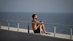 A man enjoys the sun in Barceloneta beach, in Barcelona on October 27, 2022.
