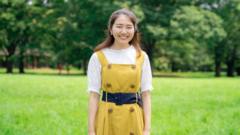 Momoko Nojo, Japanese woman stands in front of trees wearing yellow dress