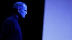 Steve Jobs lit up by blue lighting at a press event.