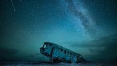 A starlit sky above an abandoned war plane