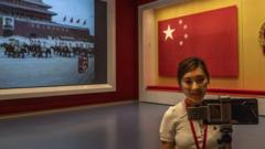 A journalist films next t o a large screen and original national flag at the newly built Museum of the Communist Party of China on June 25, 2021 in Beijing, China.