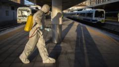 A health worker sprays a train station in Spain