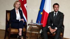 British Prime Minister Liz Truss, left, poses with France's President Emmanuel Macron during a meeting on the sidelines of the European Political Community meeting at Prague Ca