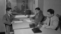Rekaman acara 'Inggris pekan ini' untuk BBC Siaran Timur Jauh, bersama penyiar Ir R.M. Soediro, L.E.S. Wairatai dan R.T. Kamaraga, dari BBC Indonesia, beserta G.A.M. Hils yang berada di ruang kontrol (kanan, berdiri), 12 Februari 1951.