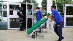 Homens carregando cilindros de oxigênio para hospital de Manaus