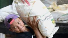 Worker carrying sack after Indonesian customs seizure in 2016