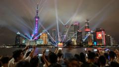 Spectators look at a light show on the Bund promenade in Shanghai