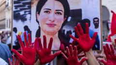 Protestors in Italy with hands marked red gather to remember Hevrin Khalaf