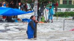 A woman clings to a lamp post during flooding caused by heavy rains in Sucre, Bolivia January 4, 2021