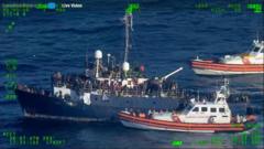 The Italian coastguard approaches a boat carrying migrants in the Ionian Sea, close to Sicily and Calabria on 10 April