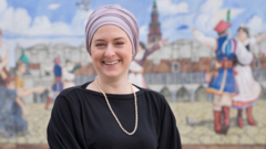 Amanda Jaczkowski, a newly elected city councilmember in Hamtramck, poses in front of murals honouring the city's Polish heritage.
