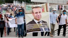 Протестующие с плакатом с изображением Орхана Инанды
