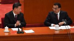 China's President Xi Jinping (L) talks with Premier Li Keqiang during a celebration meeting marking the 40th anniversary of China's 