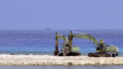 Two excavators are pictured at a construction site on Taiping island in the Spratly chain in the South China Sea on March 23, 2016.