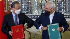 Chinese Foreign Minister Wang Yi and Iranian Foreign Minister Mohammad Javad Zarif bump elbows during the signing ceremony of a 25-year co-operation agreement in Tehran, Iran (27 March 2021)