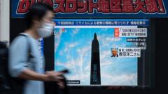A man walks past a public television screen in Tokyo on October 4, 2022, displaying a broadcast about an early morning North Korean missile launch