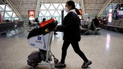 成都雙流國際機場一位旅客推著行李車走過候機旅客（30/12/2022）
