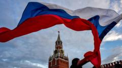 A Russia fan waves the Russian national flag as fans celebrate at the Red Square in Moscow