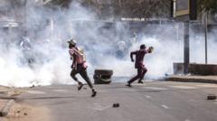 Des manifestants fuient les gaz lacrymogènes lors d'affrontements avec la police à Dakar, le 9 février 2024. 