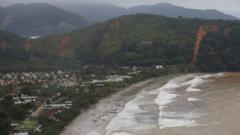 Foto aérea mostra praia e encostas com deslizamentos