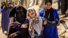 Une femme est aidée alors qu'elle réagit à la mort de membres de sa famille au sud-ouest de Marrakech.