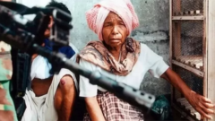 Seorang perempuan warga Lhokseumawe, Aceh, dan seorang lainnya, di hadapan seorang anggota TNI, saat wilayah itu masih dilanda konflik bersenjata, 25 Mei 2003. (Foto ilustrasi).