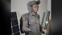 Officer Babangida wear im uniform and hold baton with one hand