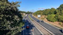A lane closure on the A14 near Orwell Bridge. Cones block one lane of the carriageway closest to the camera. A line of cars can be seen moving.