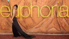 Zendaya in a black dress standing on the red carpet in front of large letters spelling "Euphoria" at the premiere