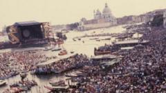 Crowds of people, the Venice skyline in the background and a large open-air stage
